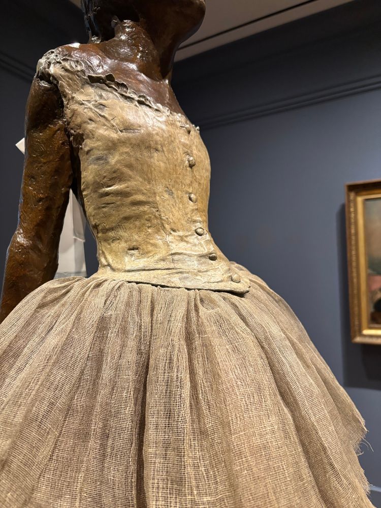 Detail of one of the bronze versions of Degas’ Little Dancer Aged 14, cast between 1919 & 1930. The original, sculpted in wax w/a tulle skirt, human hair, & a silk hair ribbon, was first exhibited at the 1881 Impressionist exhibition.