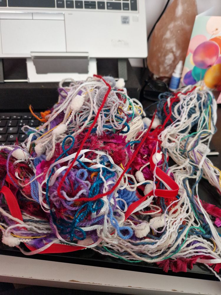 A big tangle of yarn with lots of different colours and textures. 