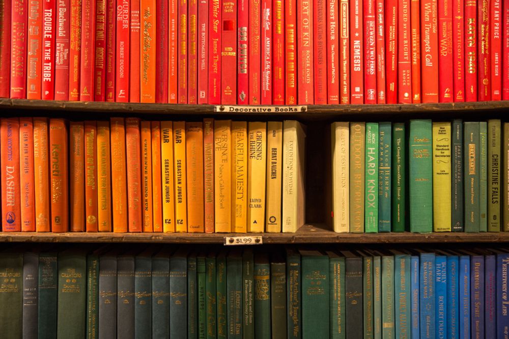 Three shelves of brightly coloured books
