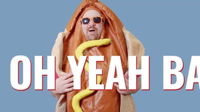 a man in a hot dog costume is holding a hot dog