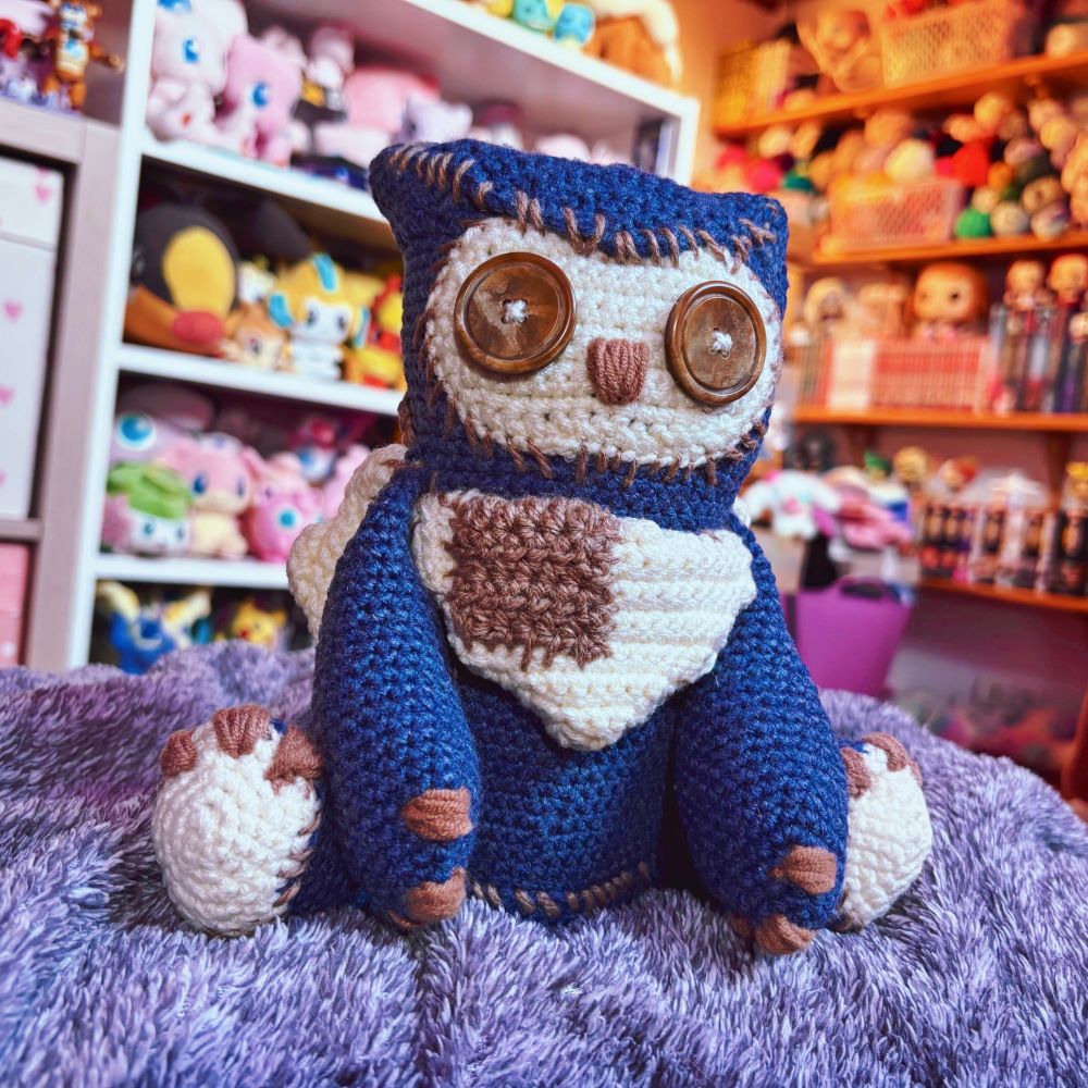 photo of a blue crocheted owlbear plushie