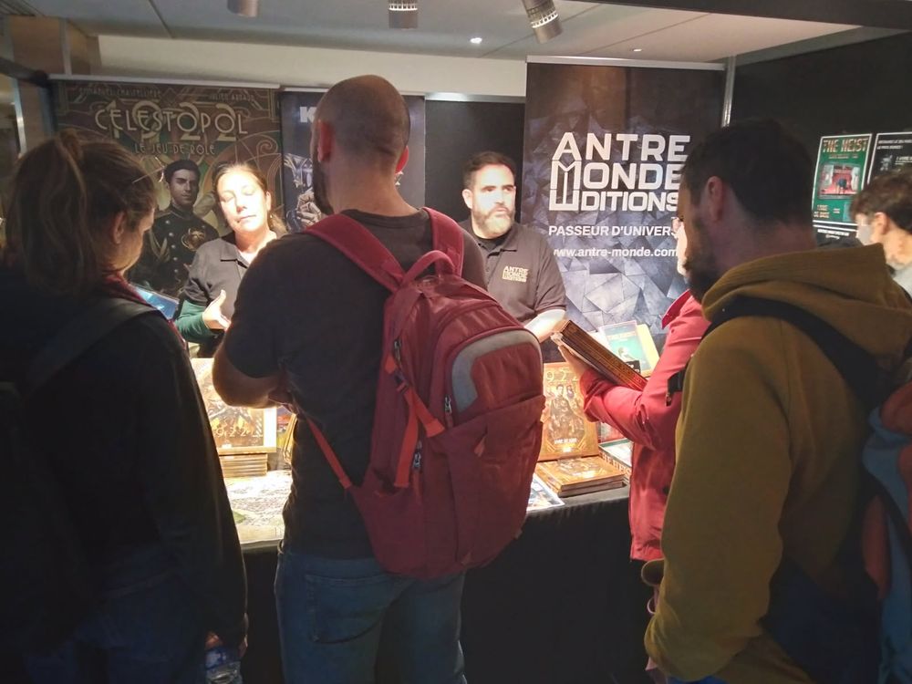 Le stand des éditions Antre Monde aux Utopiales 2025, avec le jeu de rôle Célestopol 1922. 