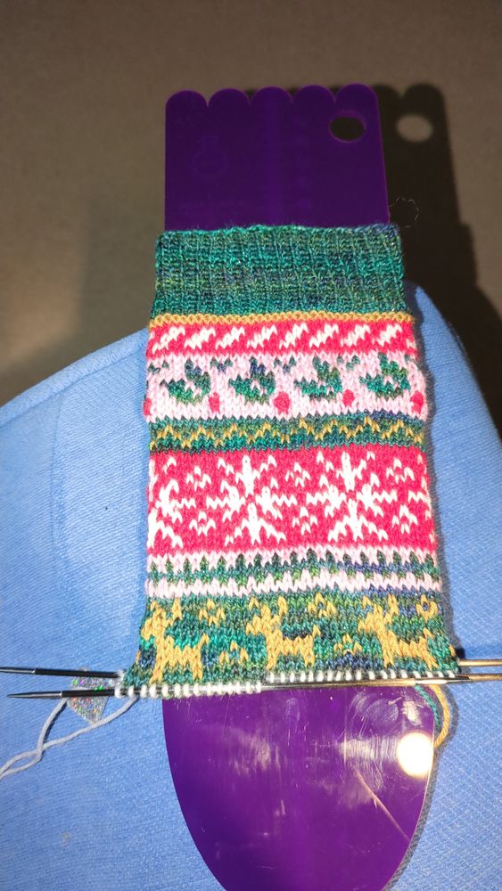 A colourwork sock in progress.
Motifs are holly leaves, snowflakes and reindeer. 