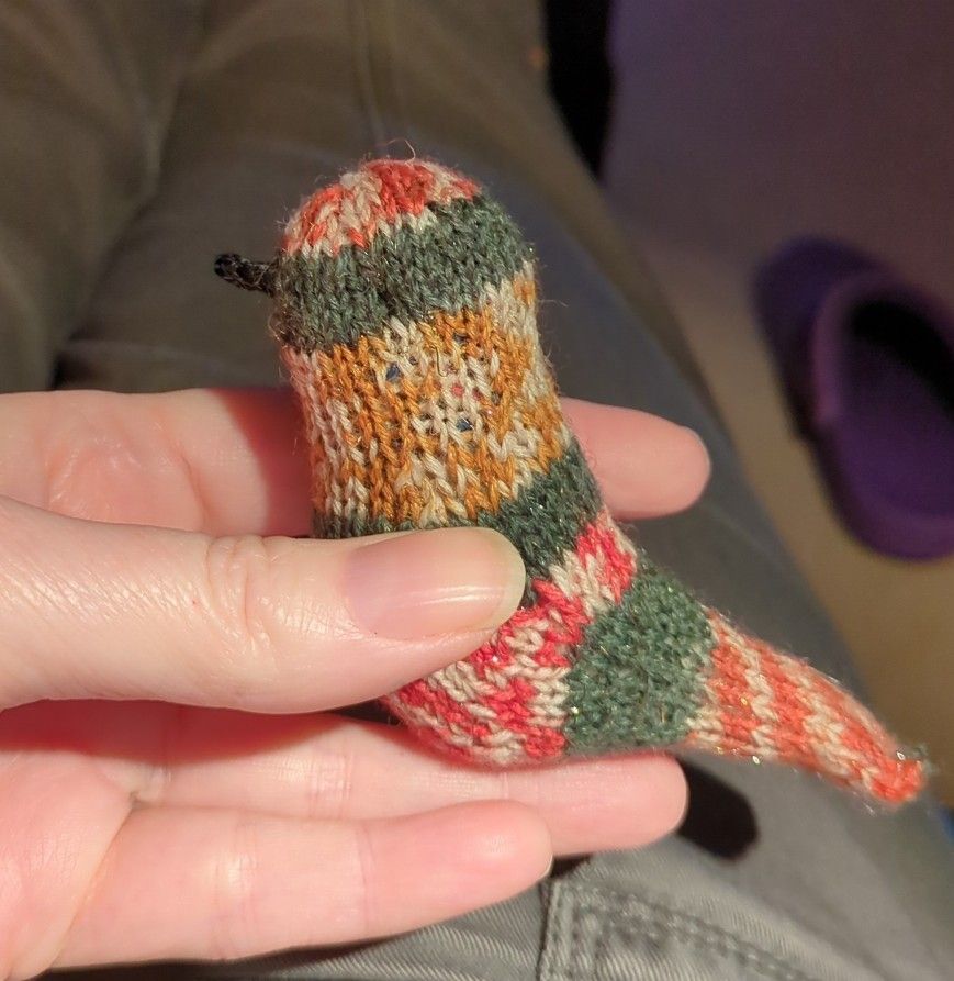 A small handknit bird made out of Christmas self striping yarn.