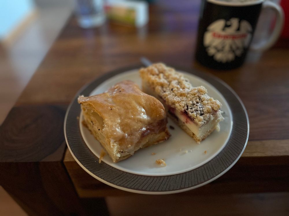Ein Teller mit zwei Stücken Kuchen. Im Hintergrund eine Eintracht Frankfurt Tasse.