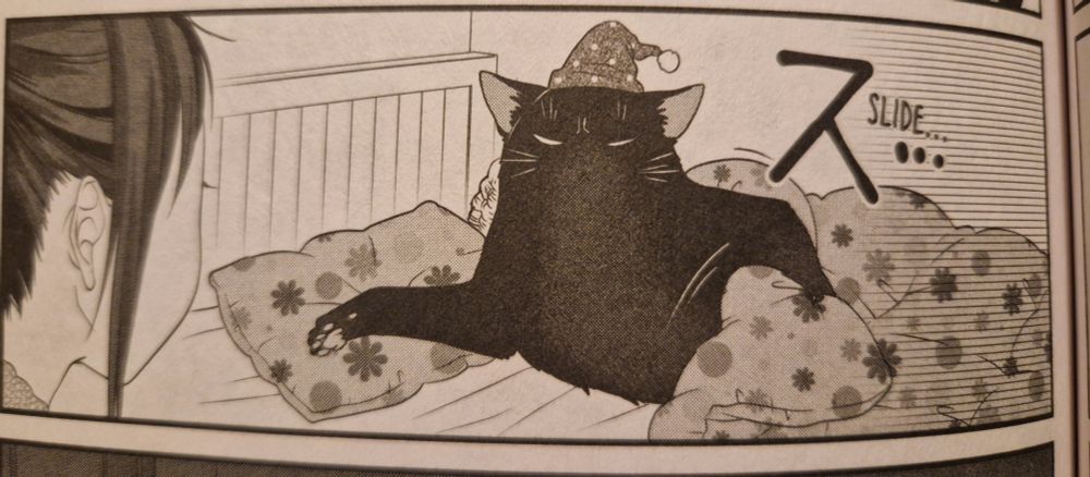 A panel from volume 2 of The Masterful Cat is Depressed Again Today, showing a bigger than human sized black cat in an old fashioned nightcap, lying on his side in bed while pulling back the sheets and draping an arm over the pillow next to him, encouraging his owner to get into bed.