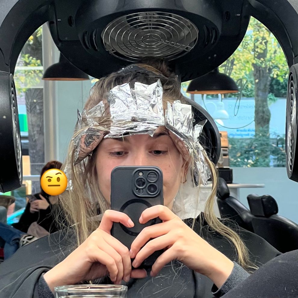 sitze in frisörsalon mit alufolien in den haaren wegen blondierung und mache ein spiegelselfie, um mich herum son lustiges hitze gerät