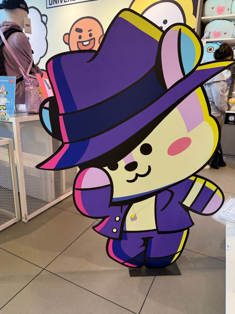 A cardboard cutout of Mang in a purple suit dancing
