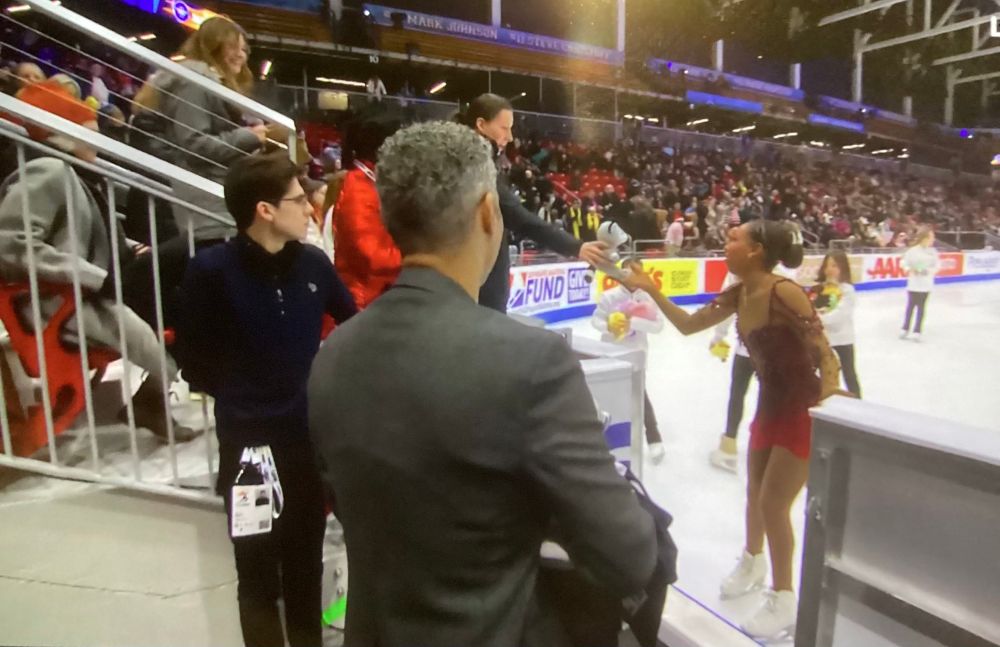 Screenshot from skate America of a black athlete, Starr Andrews, reaching out for a small raccoon plush held out by an older white woman in the stands.

As soon as Starr recognized the plush she put her hand down without taking it and told the woman she couldn’t accept it.