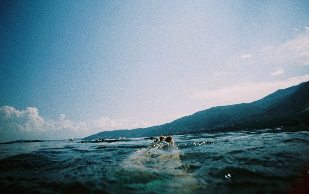 The photo shows my toes in the water of Lake Maggiore. In the background, you can see the lake's beautiful mountain panorama.