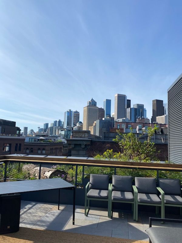 View from Fern, the rooftop bar at Populus Seattle in Pioneer Square. Seattle city skyline in the background. 
