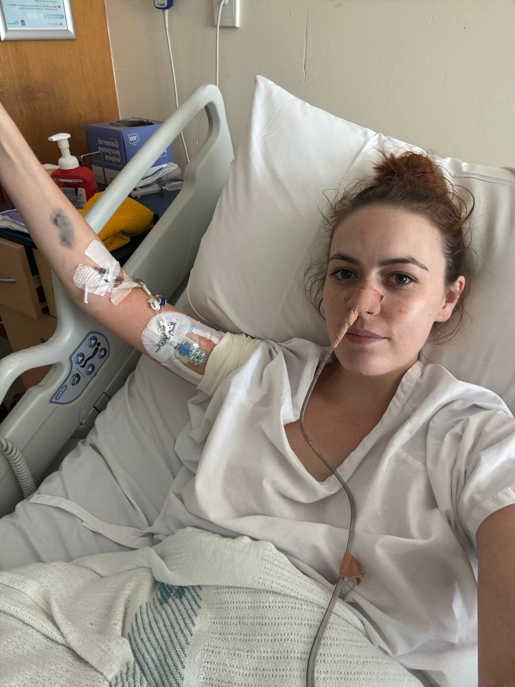 Girl in hospital bed with nasal gastric tube and cannula and PICC line in her left arm for medical treatment 