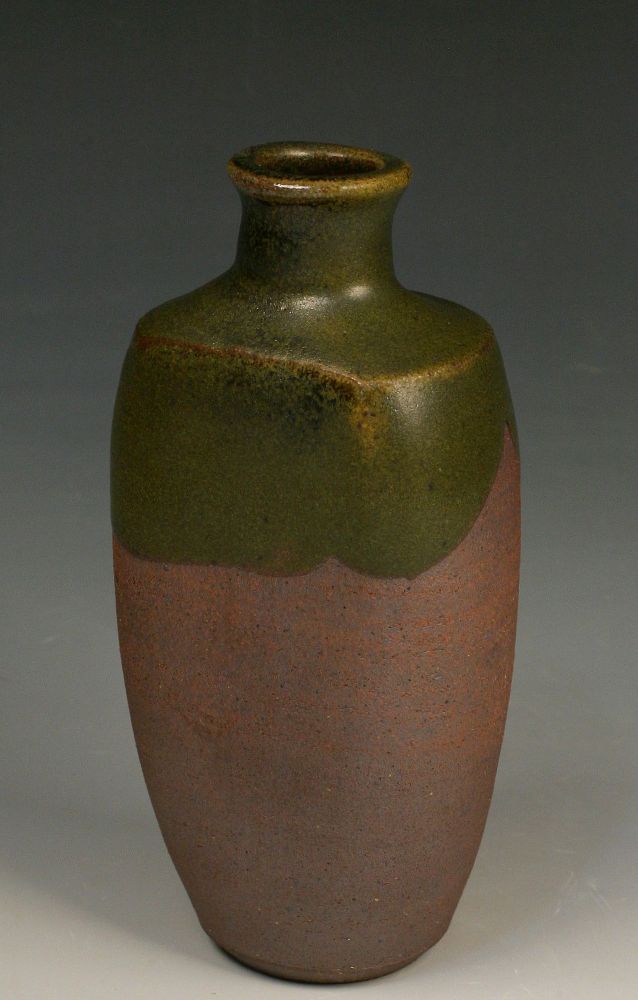 dark green matt glaze on a 7 inch paddled bottle, glazed halfway from top to middle.  The green breaks yellow on the edges. The unglazed body is dark brown.