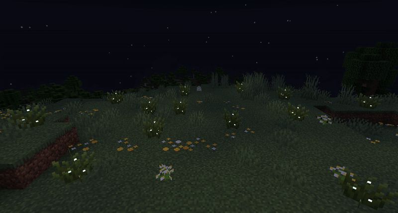 A gif showing firefly bushes on a night sky background emitting a variety of blue fairy particles