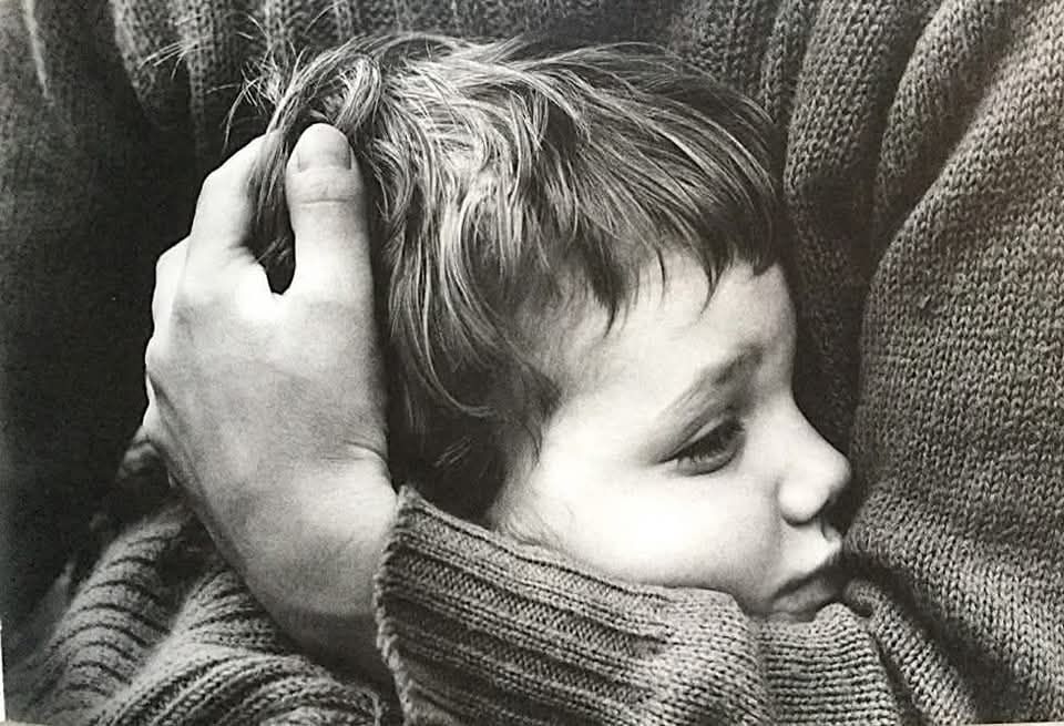 Un adulte serre dans ses bras un enfant qui semble malheureux 
