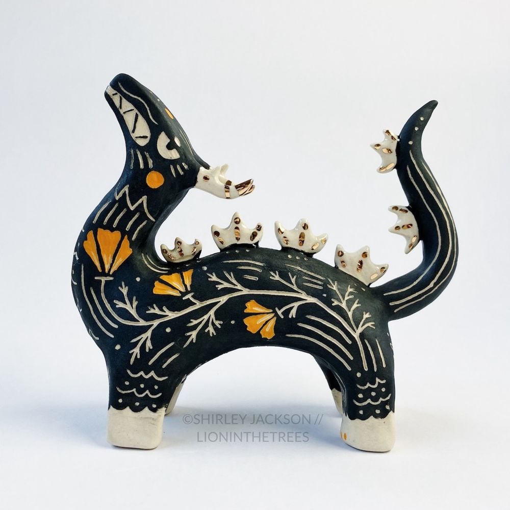 Large sgraffito dragon totem with California Poppy motifs carved into it's side, and gold glaze details on it's spine and antlers. Done with black and orange underglazes. Left side view.