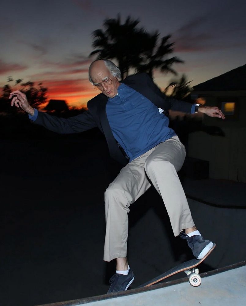 Another picture of Tony Hawk in his Larry David costume skateboarding. idk what the technical skate term is for what he's doing here in the picture, but it looks like he's trying to "catch" the lip of the bowl with his front truck.