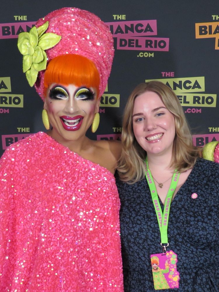 Drag queen Bianca del Rio poserer smilende med meg. Bianca har voldsom drag-sminke, oransje hår, rosa paljetturban og -kjole, mens jeg er ganske vanlig med lyst hår og blåsvart kjole.