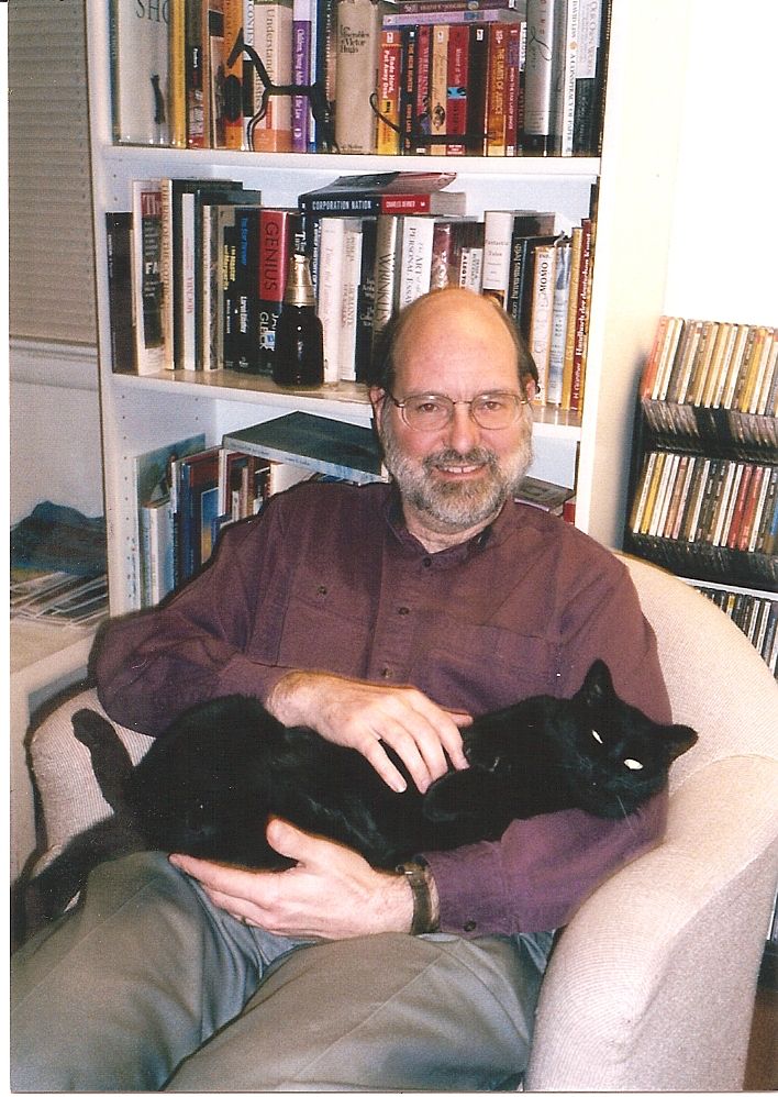 Lucy, a black cat, has a look of triumph as she lies on her human's lap.
