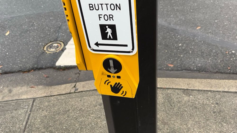 An up-close shot of the Campbell Guardian Wave audible push-button, with the arrow pointing down to the ground.
(Quadra St at Caledonia Ave)