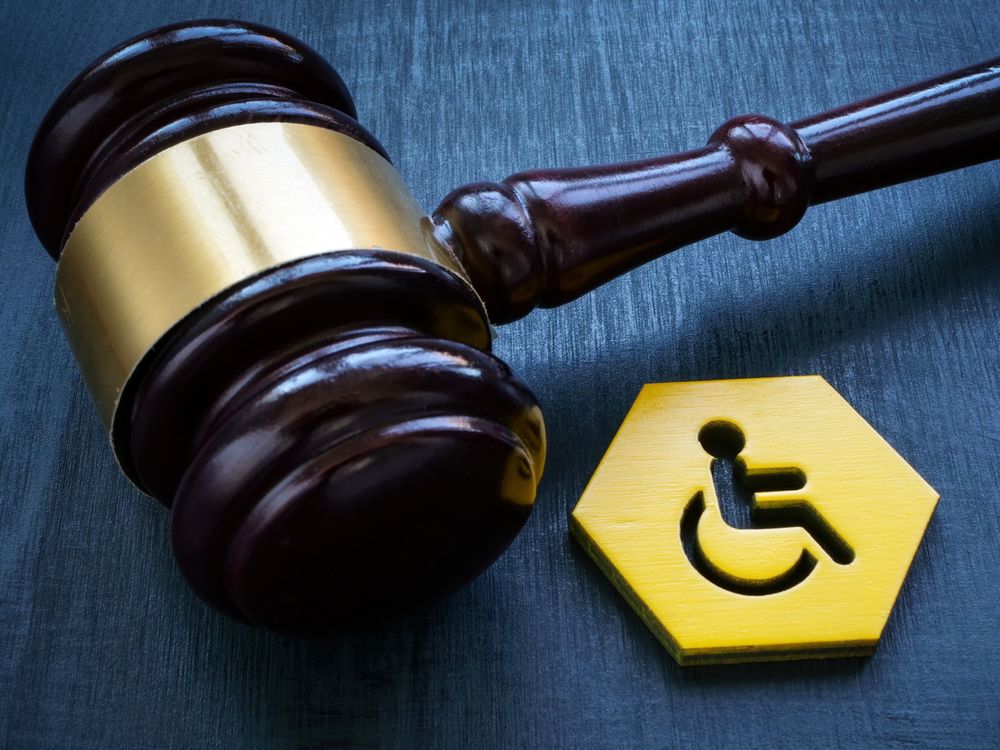 A gavel next to the international symbol of accessibility.
