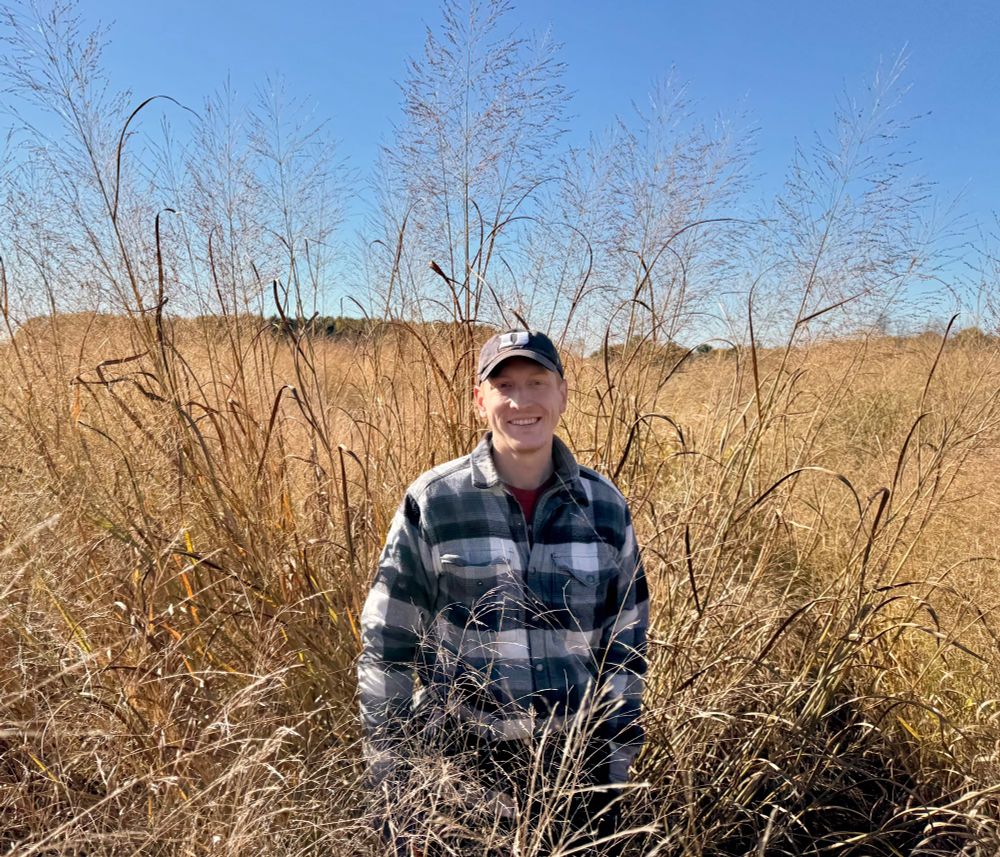 Andrew in plaid in front of dried switchgrass. 