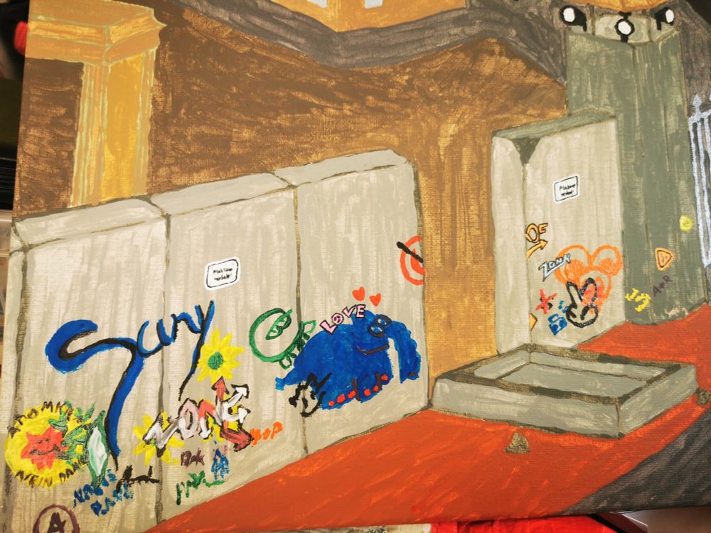 Eine graue Betonwand aus der eine Platte umgefallen ist. Auf der Wand sind diverse Bildchen zu sehen, ein "Atomkraft Nein Danke", ein Ottifant, ein Schriftzug "Suny" und anderes.