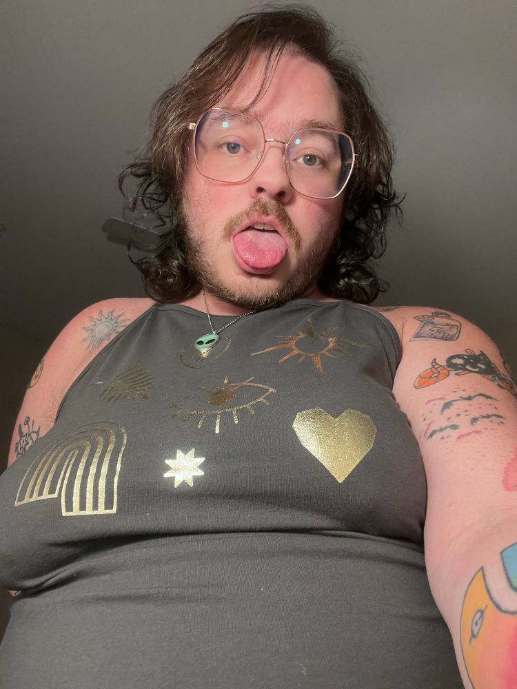 selfie of honey from a low angle, tongue out, nipples prominent 