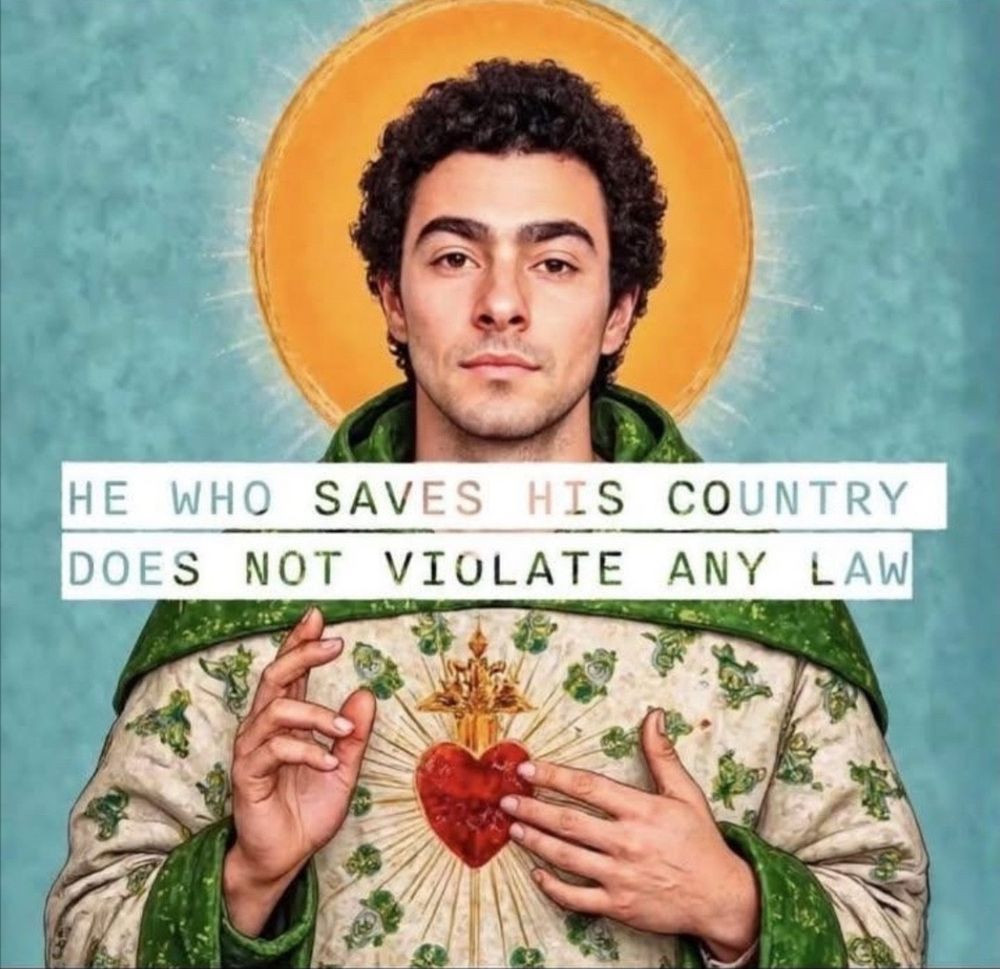 An AI-generated image of Luigi Mangione as a saint in green vestments and with a golden halo. His right hand is held up and slightly raising the first two fingers, and his left hand is pointing towards a red heart in his chest that glows with its own halo. Superimposed over the image is text that quotes Donald Trump, who was originally speaking of Jan. 6 rioters, “He who saves his country does not violate any law.”