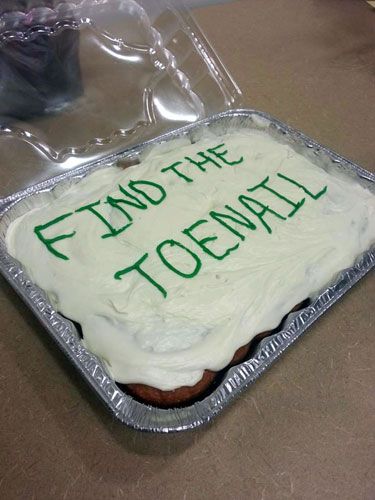 A birthday cake with the words, FIND THE TOENAIL written on it. 