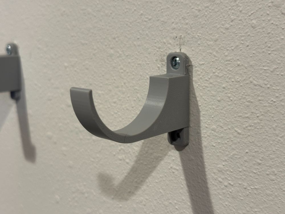 closer photo of a grey bracket attached to a white wall.