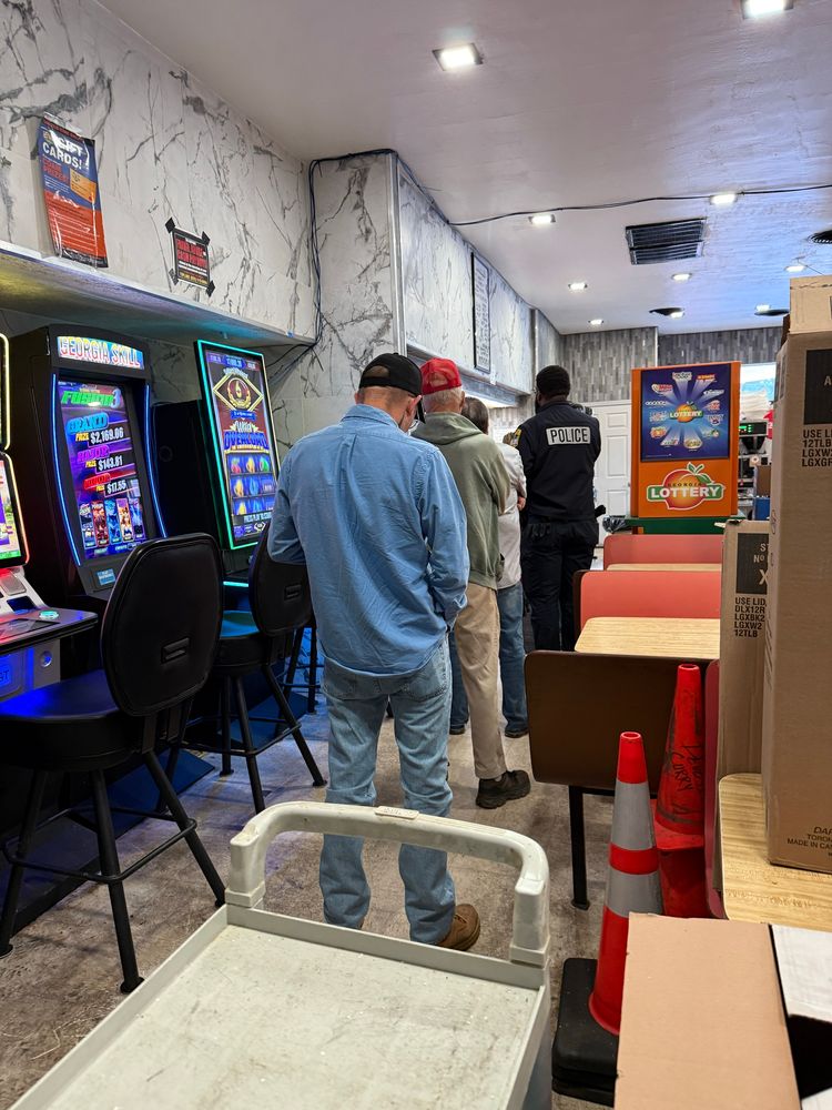 people waiting in line next to video poker machines in a gas station restaurant 