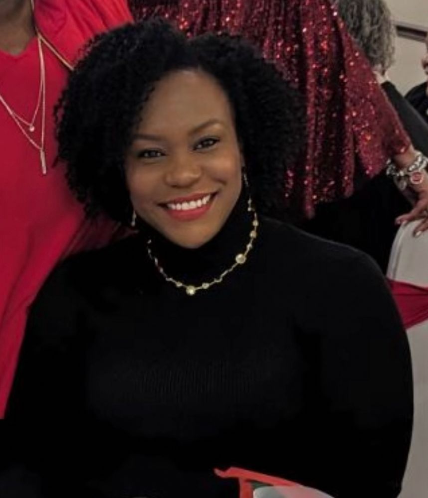 Me at a Christmas party in a black turtleneck and gold necklace looking like that old picture of The Rock