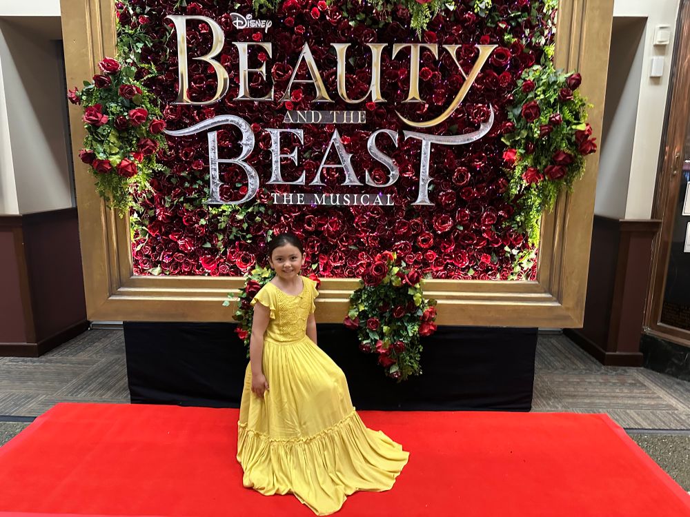 An actress playing Chip the Cup in the new Broadway tour of “Beauty and the Beast” poses on the red carpet. 