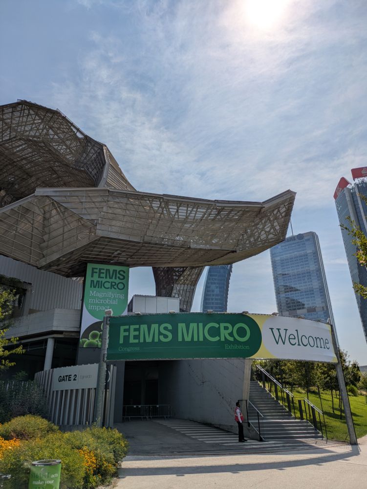 Photo of the outside of a convention center with a green banner that says FEMS micro -- welcome