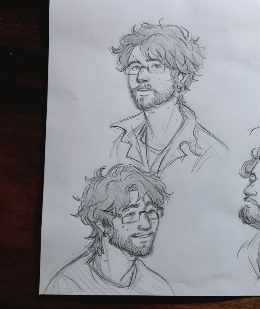 Ilustração tradicional em grafite do personagem Youssef, dois rostos dele. Ele é um homem de cabelos curtos, ondulados e desgrenhados e barba. Usa óculos e brincos de argolas pequenos nas duas orelhas. Tem algumas pintinhas no rosto.
No desenho acima, ele está com a face levemente levantada, pensativo.
No desenho abaixo, ele está sorrindo.