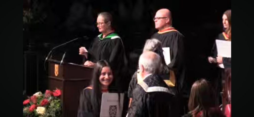 Middle aged bald fellow graduating from university.