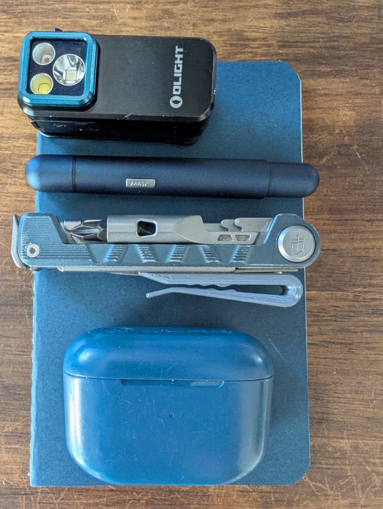 •Olight Clip Pro
•Lamy Pico
•Gerber Armbar Drive
•jLab Go Air Pop
•cheapo pocket notebook
(mostly blue items on a blue notebook)