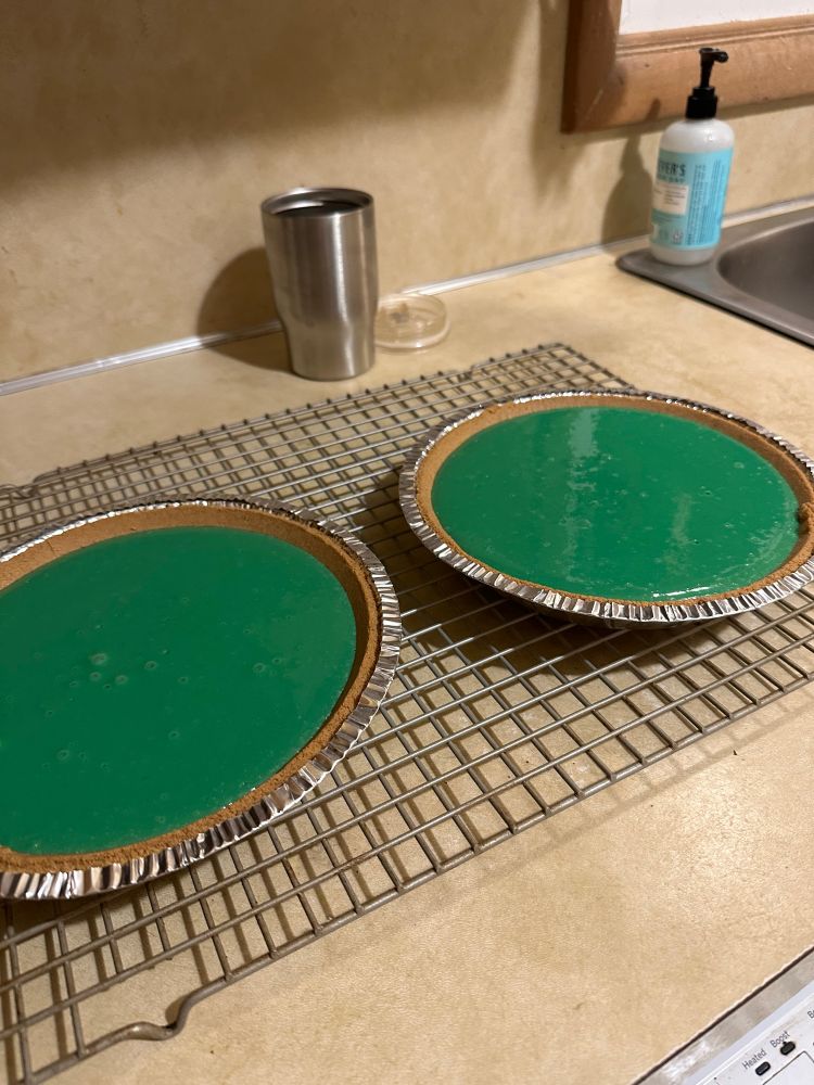 Two violently teal Baja Blast pies are cooling on a wire rack