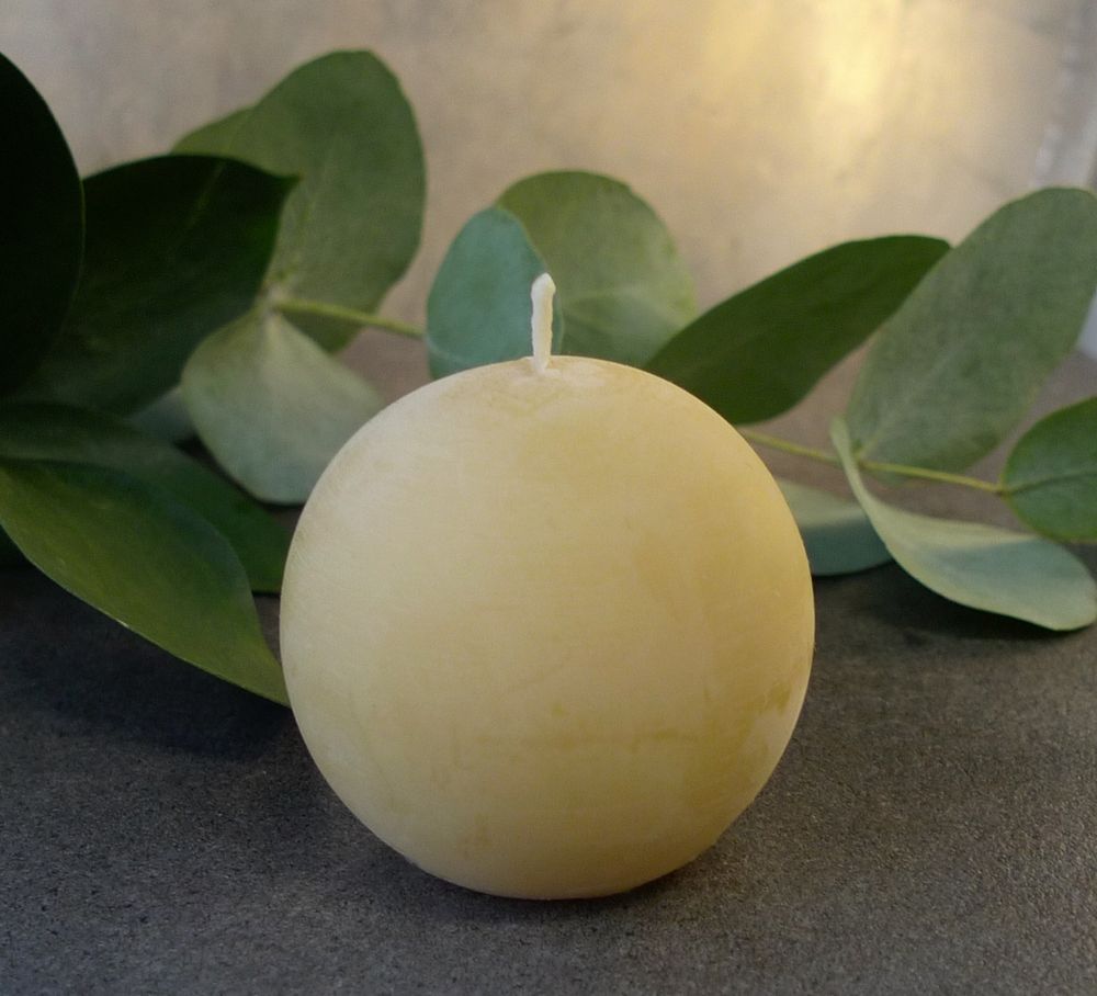 Kuvassa värjäämättömästä mehiläisvahasta valmistettu keltainen pallokynttilä. #kynttilä #mehiläisvaha #käsityö