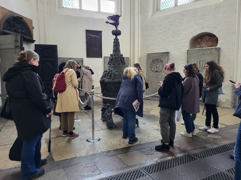 St Mary's in Rostock, a group of people around the medieval baptismal font 
