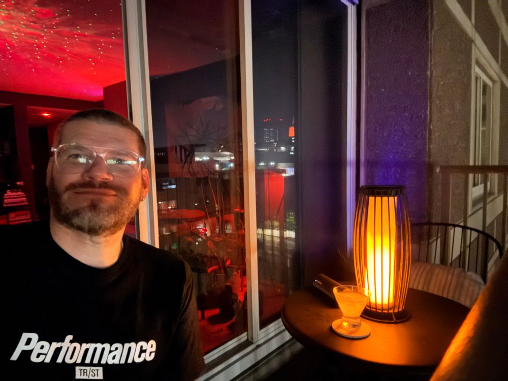 Me sitting on balcony at night with martini and a torch light 