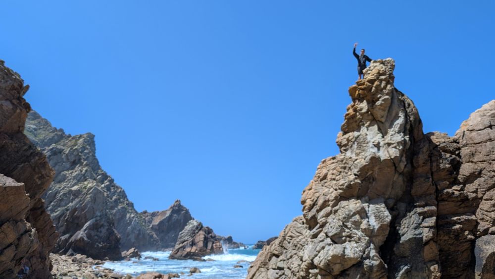 Ian climbing rocks by the Atlantic Ocean in Portugal