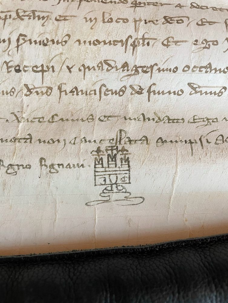 A 14th-century parchment manuscript with a doodle of a castle at the bottom. The Latin document is written in crabbed notarial hand.