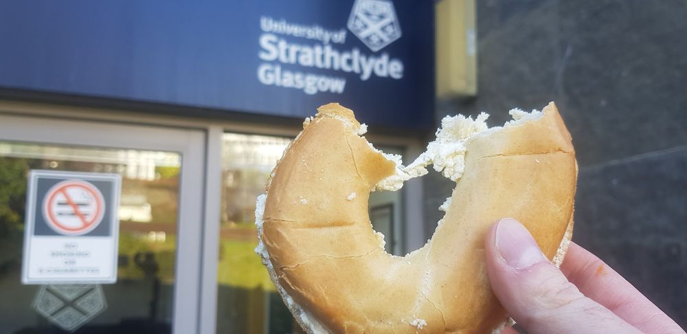 A partly-eaten bagel underneath a university of Strathclyde logo.