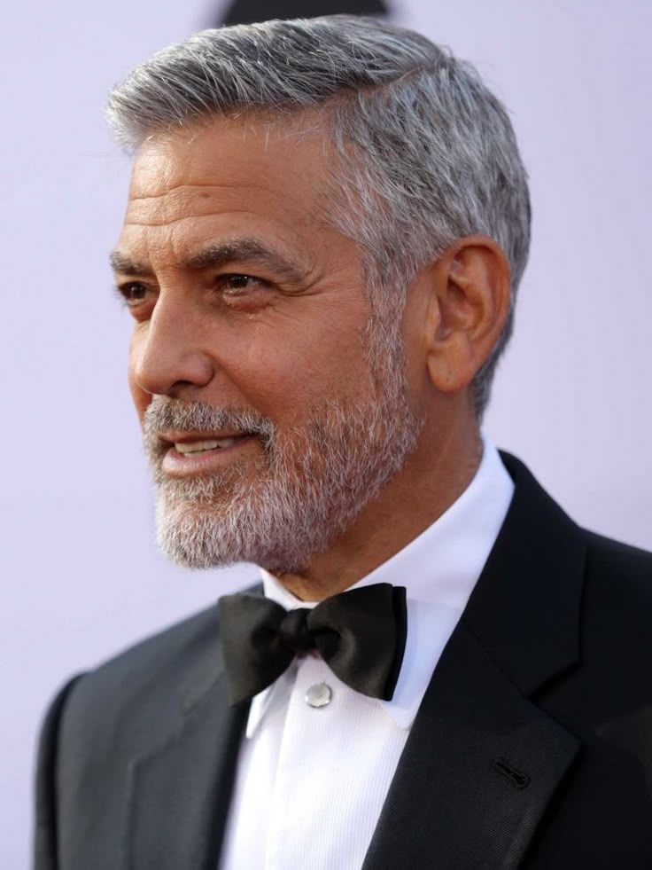George Clooney with ashort grey beard in a suit, looking dapper