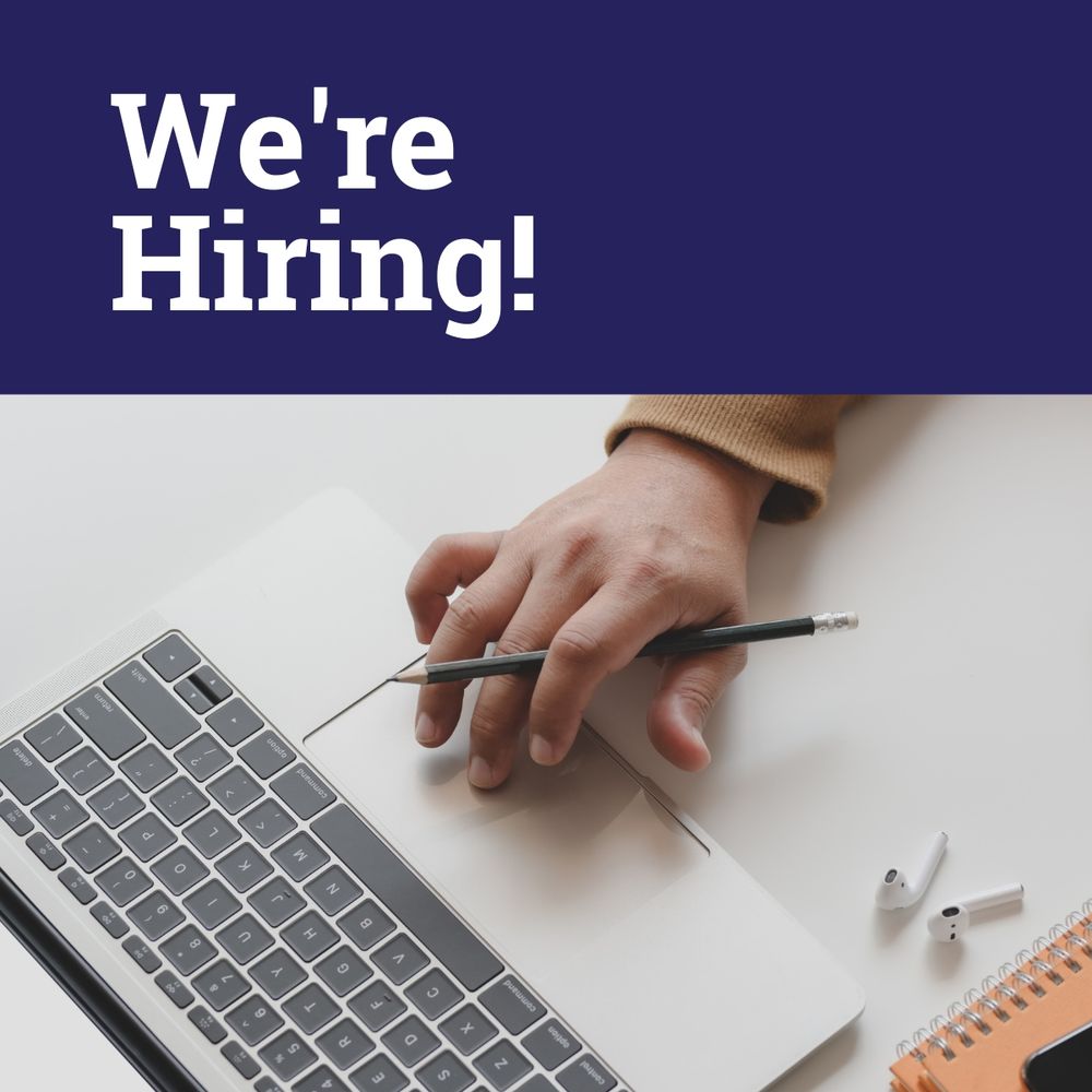 A hand with a pencil between the fingers scrolls a laptop. Text: We're hiring!