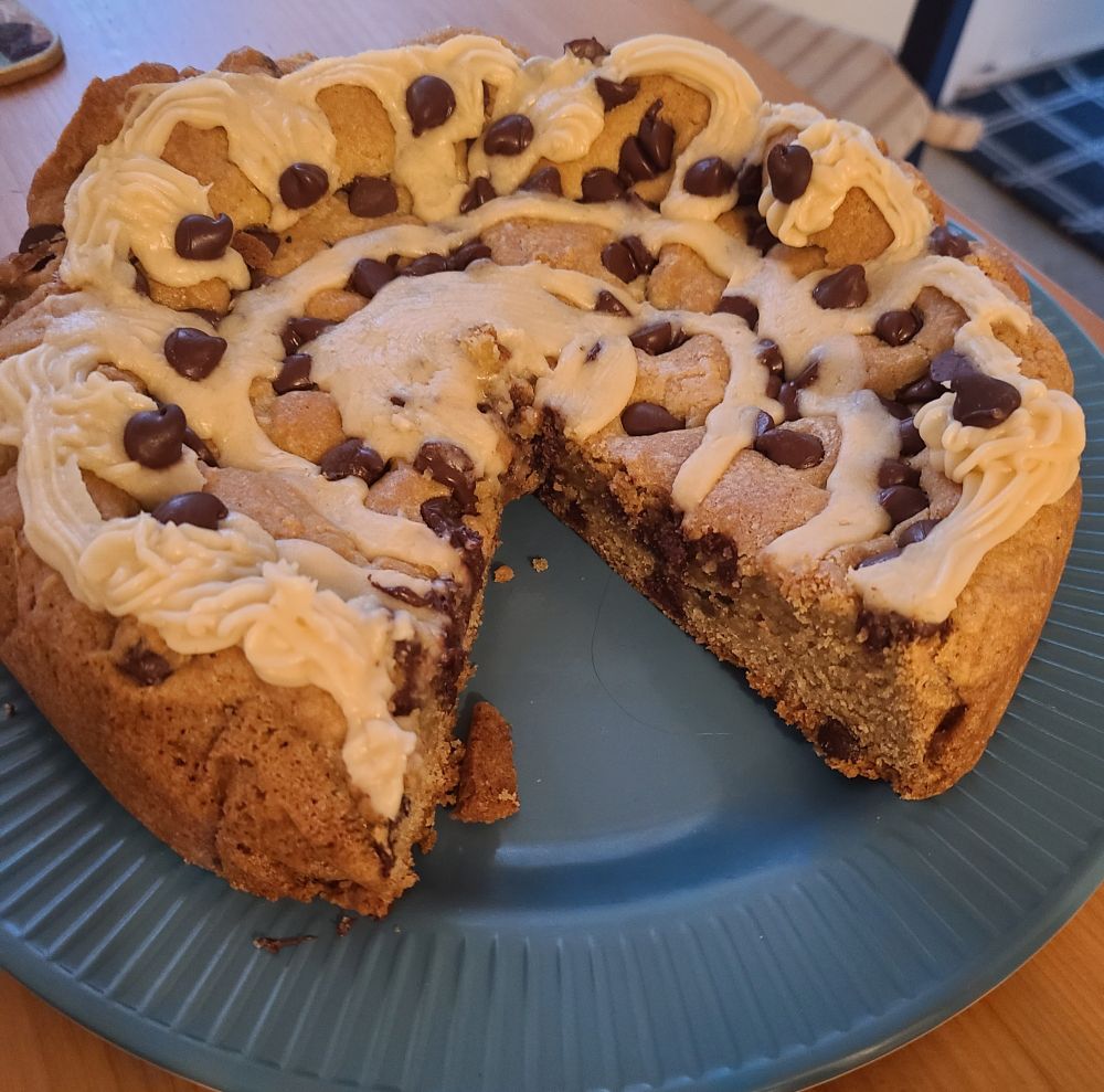 Thick chocolate chip cookie cake with cream colored frosting