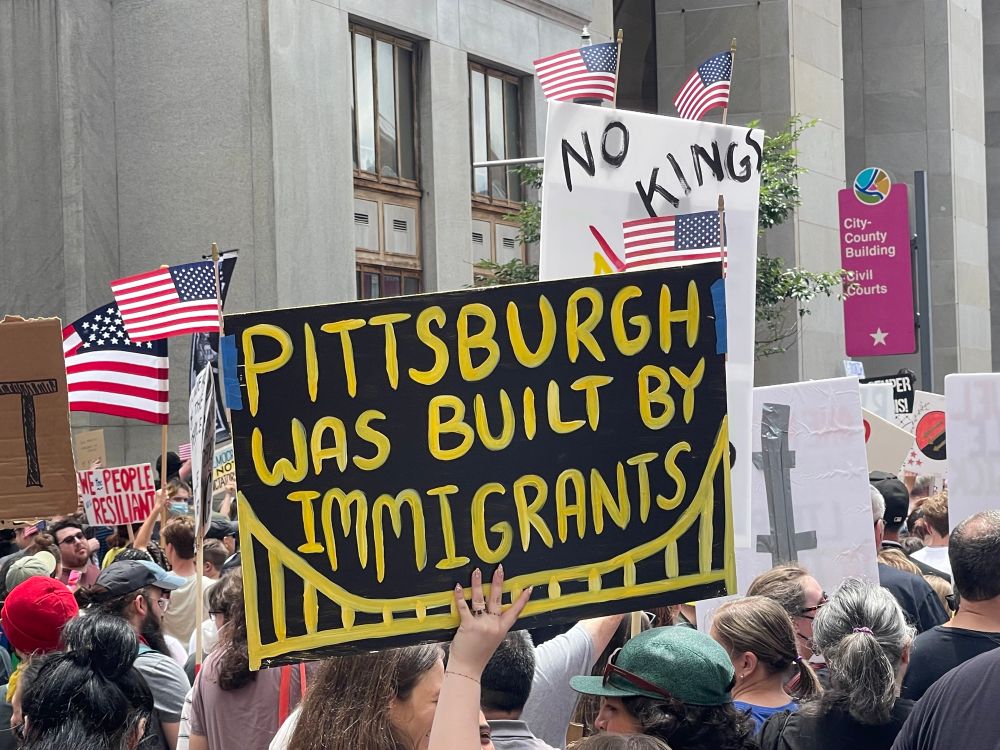 Protest sign in black and yellow (color of the Pittsburgh Steelers) that reads: “Pittsburgh was built by immigrants”. 