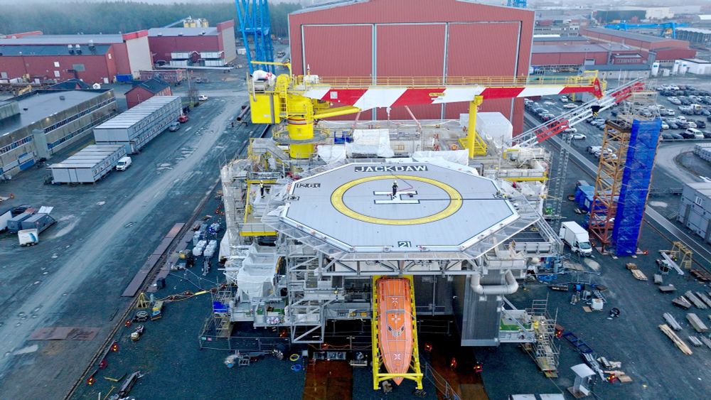 The Jackdaw oil platform towers 40m above the ground at the Aker fabrication yard in Verdal, Norway. A giant red and white crane frames the platform which is dominated by an aluminium helipad below which juts an orange lifeboat. Vehicles and workers in the yard below the structure look tiny, giving a sense of the scale of the project on which Shell says it has so far spent £800m. 